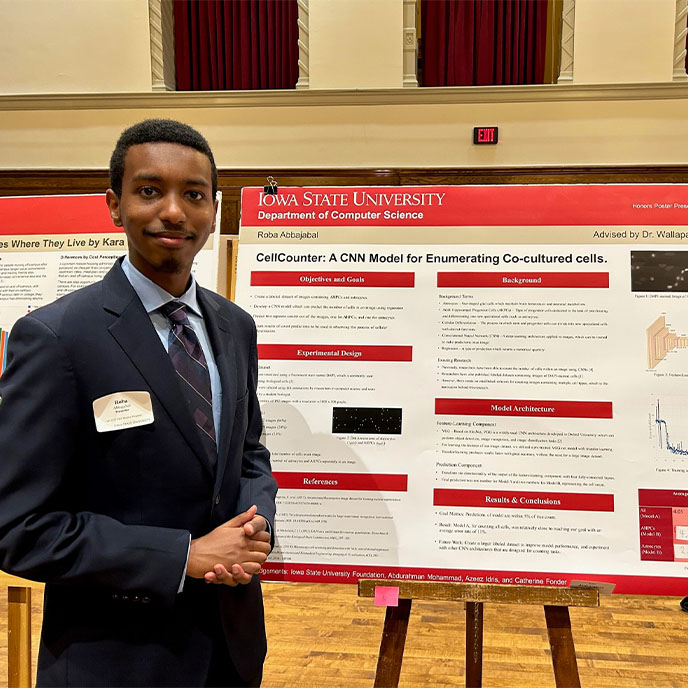 Male honors student presenting his research at the Fall 2022 poster session.
