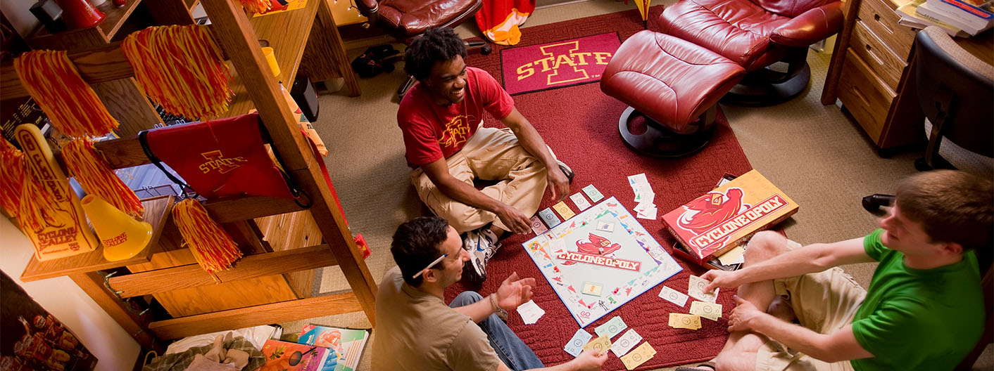 Three male students playing Cyclone Monopoly in an Iowa State University dorm.