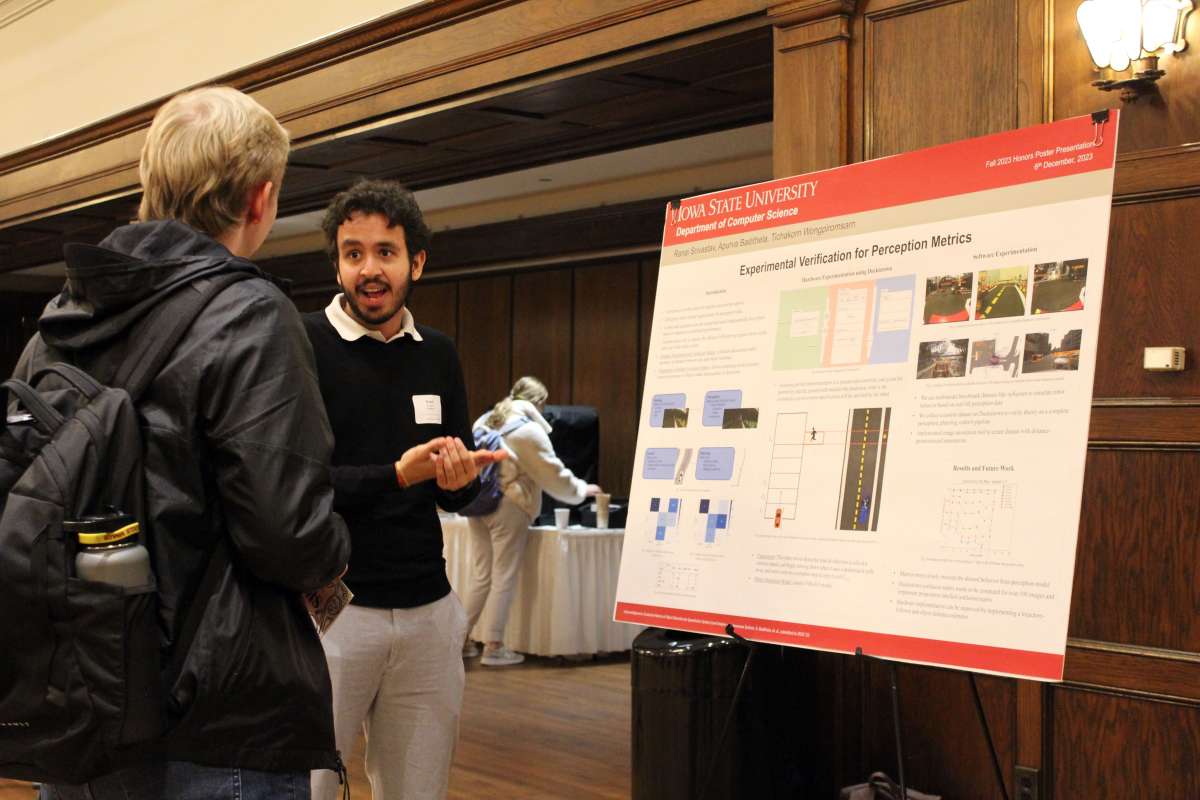 Male honors student presenting his research at the poster session.